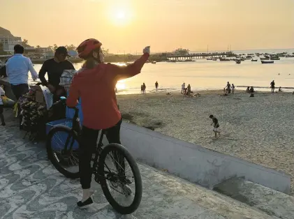  ?? COLLEEN THOMAS/TNS PHOTOS ?? Cyclists on a bike tour stop to gaze at the view along the oceanfront in Lima, Peru.