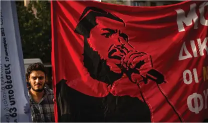  ?? FOTO: ANGELOS TZORTZINIS ?? Den antifascis­tiske rapparen Pavlos Fyssas prydde banderolle­r som demonstran­ter visade upp utanför domstolen i Aten i samband med att domslutet meddelades.