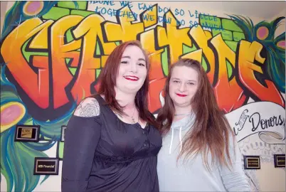  ?? NEWS PHOTO PEGGY REVELL ?? Kaitlin Affleck and Samantha Renwick smile in front of the “Gratitude” mural inside Youthopia Tuesday. An official ribbon-cutting was held for the program, which allows youth like Affleck and Renwick to have stable housing, and added supports on site...