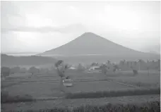  ?? AP Photo/Firdia Lisnawati ?? Mount Agung volcano spews smoke Monday in Karangasem, Bali, Indonesia. Gushing ash from Bali’s Mount Agung volcano has dissipated into a wispy plume of steam. Indonesia’s disaster mitigation agency said Monday the volcano remains at its highest alert...