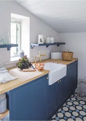  ??  ?? UTILITY ROOM
This compact space has been painted white to help make the most of the light from the small window, while decorative yet practical flooring echoes the strong blue on the cabinet doors.
Cabinets in Hague Blue, Estate Eggshell, £43.50 for...