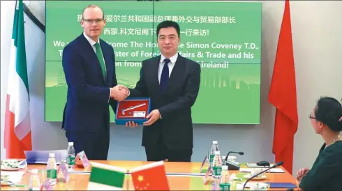  ?? CHEN WEI / FOR CHINA DAILY ?? Simon Coveney (left), deputy prime minister of Ireland, receives a gift of hammer from Xie Hui, the Party secretary of Beijing University of Technology during his visit to the Beijing Dublin Internatio­nal College at the university on March 17.