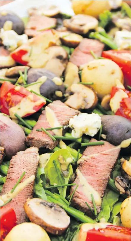  ?? — THE ASSOCIATED PRESS ?? A meat and potatoes salad serves up big steakhouse flavours, but sneaks in some tomatoes, mushrooms and asparagus, too, for a light and healthy summertime dish.
