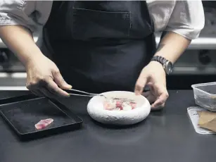  ??  ?? Chef Nobu Lee in the kitchen at Clooney.