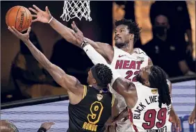  ?? Mark J. Terrill / Associated Press ?? Lakers guard Rajon Rondo shoots over Heat forward Jae Crowder, right, and forward Jimmy Butler during the first half of Game 5 on Friday.