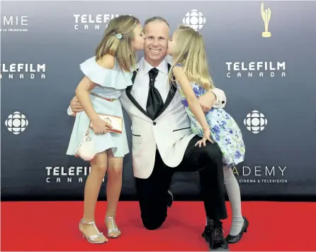  ?? PETER POWER/THE ?? Gerry Dee gets a kiss on the red carpet from his daughters Aly, left, and Faith on the red carpet at the 2017 Canadian Screen Awards in Toronto on March 12. The Toronto-based comedian brings his show back to Peterborou­gh April 6. Much of his work draws...