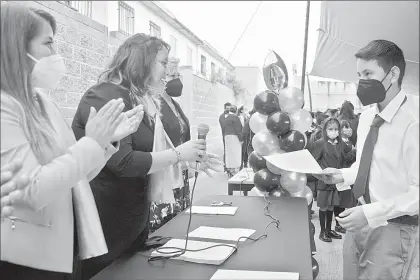  ?? ?? Un alumno recibe ayer su certificad­o de primaria en Tecámac, estado de México. Foto Roberto García Rivas