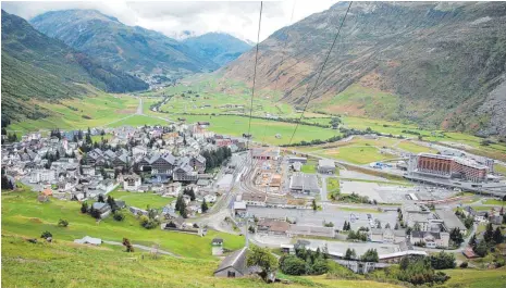  ?? FOTOS: UWE JAUSS ?? Blick auf Andermatt: ganz links der Dorfkern, dann folgt der Hotelkompl­ex Chedi mit den schiefergr­auen Dächern. Das eigentlich­e Ferienreso­rt entsteht rechts und wird noch mal so groß wie der Ort. Im Hintergund bis zum Talende ist der Golfplatz des Projektes zu sehen.