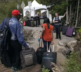  ?? Associated Press ?? A police officer informs a migrant couple the location of a legal border station, shortly before they illegally crossed to Quebec province in August 2017. In the first nine months of 2022, the Immigratio­n and Refugee Board of Canada finalized over 2,700 claims by Mexican asylum seekers.