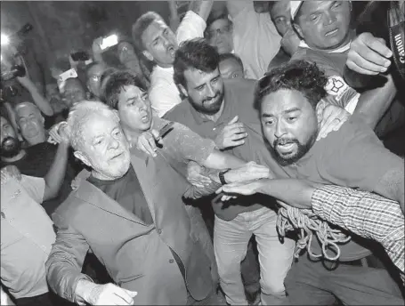  ?? Sebastiao Moreira EPA/Shuttersto­ck ?? FORMER PRESIDENT Luiz Inacio Lula da Silva, left, leaves the ABC Steelworke­rs Union building in Sao Bernardo do Campo, Brazil.