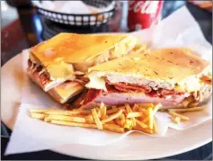  ??  ?? A Cuban sandwich – ham, slow roasted pork, swiss cheese, mustard, pickles, cilantro aioli on Cuban bread – photograph­ed at a restaurant in Miami, Florida.