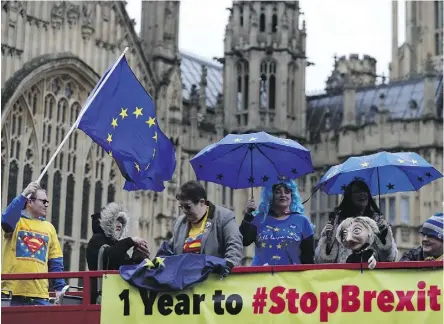  ?? DANIEL LEAL-OLIVAS/AFP/GETTY IMAGES ?? Anti-Brexit demonstrat­ors wave European Union flags from the top deck of a bus parked outside the Houses of Parliament in London on Thursday.