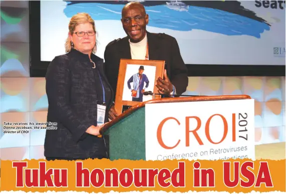  ??  ?? Tuku receives his award from Donna Jacobsen, the executive director of CROI