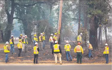  ?? Gabrielle Lurie / The Chronicle 2018 ?? PG&amp;E workers watch as trees are marked for cutting after the Camp Fire in Paradise (Butte County) in November. State law says PG&amp;E must inform employees at least 15 days in advance of a bankruptcy filing.