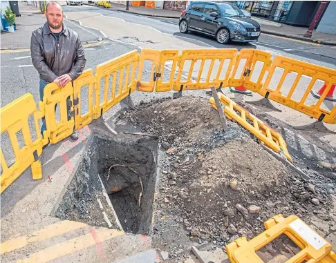 ??  ?? DIGGING IN: Councillor Darren Watt looks over the troublesom­e hole in Cowdenbeat­h. Picture by Steve MacDougall.