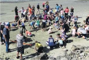  ?? PHOTOS: DANIEL BIRCHFIELD ?? Digging in . . . People hunt for prizes during the beach dig at the Friendly Bay Family Fun Day in Oamaru on Saturday.