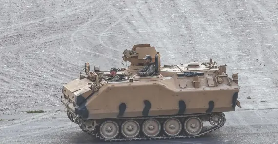  ?? AFP ?? Turkish army soldiers manning an armored vehicle near the Syrian town of Ras Al-Ain during the Turkish offensive against Kurdish groups in northeaste­rn Syria.