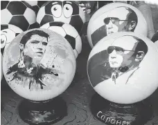  ?? EFREM LUKATSKY / THE ASSOCIATED PRESS ?? Wooden balls depicting Russian President Vladimir Putin and soccer star Cristiano Ronaldo are popular souvenirs in Russia.