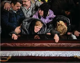  ?? Emilio Morenatti/Associated Press ?? A mother cries over the coffin of her son, a Ukrainian serviceman, during his funeral this month in Lviv, Ukraine. Tens of thousands dead, infrastruc­ture demolished, children taken from their families — and for what?