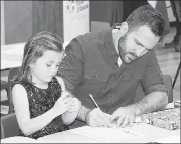  ?? SUBMITTED ?? Father and daughter enjoy colouring at one of the craft tables.