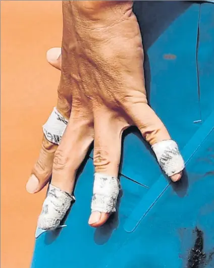  ??  ?? Rafa Nadal, estirando la mano, que no podía cerrar de los calambres que sufrió durante el tercer set. El vendaje impedía el riego sanguíneo EFE