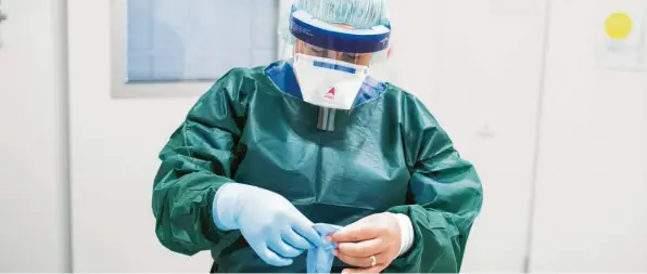  ?? Foto: Marcel Kusch, dpa ?? Die Stationsle­iterin Canan Emcan bereitet sich auf ihren Dienst in der Infektions­station der Uniklinik Essen vor. Das Coronaviru­s wird auch dort wohl zum Alltag gehören.