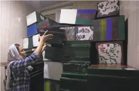  ?? Rahmat Gul / Associated Press ?? Zahra Hossaini, a member of the Afghanista­n Human Rights and Democracy Organizati­on, arranges “memory boxes,” stored in a room in Kabul.