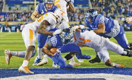  ?? THE ASSOCIATED PRESS ?? Kentucky running back Benny Snell Jr. scores a touchdown between Tennessee linebacker­s Daniel Bituli, left, and Quart’e Sapp during the first half of Saturday’s SEC East matchup in Lexington, Ky.