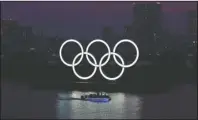  ?? The Associated Press ?? ONE YEAR TO GO: The Olympic rings float in the water at sunset in the Odaiba section on June 3 in Tokyo.