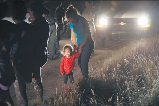  ?? JOHN MOORE Getty Images ?? A HONDURAN girl and her mother are detained in McAllen. This year 108,000 migrants were caught crossing illegally in the Rio Grande Valley, 36% of them families.