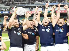  ?? — AFP photo ?? Scotland's captain John Barclay (front L) holds the trophy as he celebrates with teammates after they defeated Australia in their rugby union Test match in Sydney on June 17, 2017.