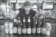  ?? Matt Carter arranges beers at the Hangar Lounge before opening. riCardo b. brazziell / ameriCan-statesman ??