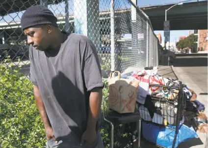  ?? Photos by Paul Chinn / The Chronicle ?? Above: Terrance Banks stands with his belongings at a homeless encampment at Vermont and 15th streets after having to move from a camp a block away after a sweep by city workers. Below: Darrell, who also relocated, rests at the camp.