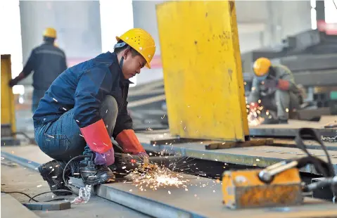  ?? ?? Workers weld materials in a workshop in Taiyuan City, north China’s Shanxi Province. — CFP