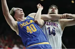  ?? AP Photo/Ralph Freso ?? ■ UCLA center Thomas Welsh (40) and Arizona’s Dusan Ristic (14) wait for a rebound during the second half of an NCAA game Thursday in Tucson, Ariz. UCLA won, 82-74.