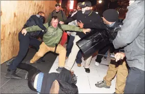  ?? Tasos Katopodis / Getty Images ?? A police officer tries to break up a fight between Black Lives Matter protesters and members of the Proud Boys during a protest following the “Million MAGA March” from Freedom Plaza to the Supreme Court, on Nov. 14 in Washington, D.C.