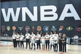  ?? CHRIS O'MEARA/AP ?? Members of the Minnesota Lynx lock arms as teammate Napheesa Collier, not shown, reads a statement regarding the death of Breonna Taylor before Game 2 of a WNBA playoff series against the Seattle Storm.