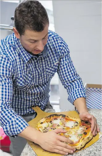  ?? CRYSTAL SCHICK/ CALGARY HERALD ?? Fausto Ricioppo readies a pie for slicing at the family-run Azzurri Pizzeria, which recently opened its doors on Edmonton Trail N.E.