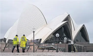  ?? AFP ?? Police officers walk past the Sydney Opera House yesterday, a day before the expected easing of coronaviru­s restrictio­ns.