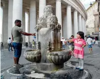  ?? AFP ?? People fill their water bottles from a fountain near St Peter’s Square, just outside Vatican city in Rome. —