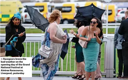  ?? Iain Watts ?? > Racegoers brave the bad weather on the opening day of the Grand National Festival at Aintree Racecourse, Liverpool, yesterday
