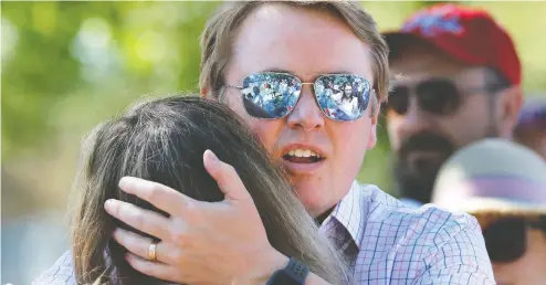  ?? LARRY MACDOUGAL / THE CANADIAN PRESS ?? Alberta Health Minister Tyler Shandro hugs his wife Andrea on Thursday after they and their family were heckled by protesters in Calgary.