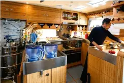  ??  ?? Clockwise from right: the pilothouse with all safety equipment to hand – here showing one of two stowable ‘granny bars’ – leads to the spacious saloon; kettle on the Refleks diesel stove; seaworthy galley with electric oven and custom hob; lifejacket stowage numbered for each crew