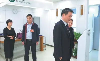  ?? FENG YONGBIN / CHINA DAILY ?? NPC Deputy Zhao Wanping (right) visits Beijing Union Clinic Partner and tests a device on Thursday.