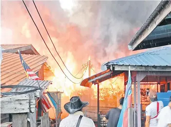  ?? ?? The houses on fire at Kampung Tanjung Batu in Tawau.