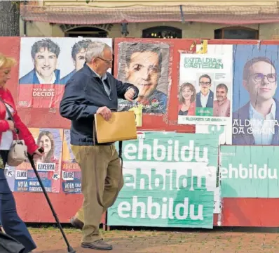  ?? ADRIÁN RUIZ HIERRO (EFE) ?? Un hombre pasaba ayer delante de un panel con propaganda electoral en Vitoria.