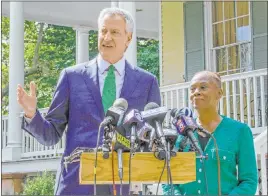  ?? Stephen Groves The Associated Press ?? New York City Mayor Bill de Blasio, flanked by his wife, Chirlane Mccray, speaks during a news conference Friday in front of Gracie Mansion in New York.