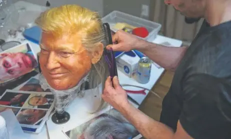  ?? Daniel Brenner, Special to The Denver Post ?? Meier grooms the hair on a mask of President Donald Trump.