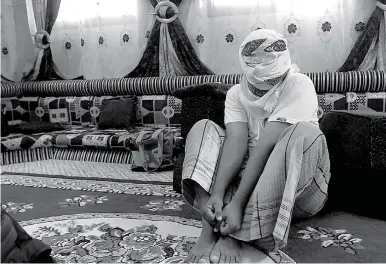  ?? AP Photo/Maad El Zikry ?? A former detainee shows how he was kept in handcuffs and leg shackles while held in a secret prison at Riyan airport in the Yemeni city of Mukalla in this May 11 photo. He covered his face out of fear of being detained again. He and other former...