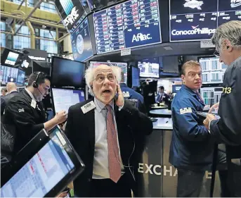  ?? / SPENCER PLATT/GETTY IMAGES ?? Traders on the floor of a stock exchange. It is recommende­d to diversify a portfolio to include global assets.